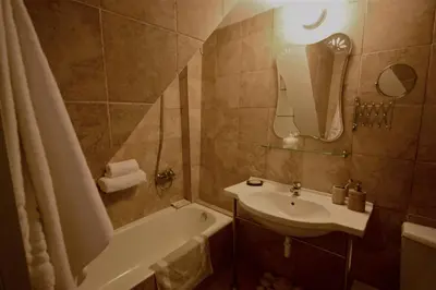 a bathroom with a sink and a tub and a toilet and a mirror at La Fiora Old Town Chania in Chania Town