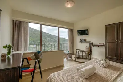 a bedroom with a bed and a desk and a large window at Seli Chrysi - Apartment near the Sea in Kámbos