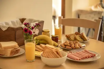 a table with plates of food and glasses of orange juice at Seli Chrysi - Apartment near the Sea in Kámbos
