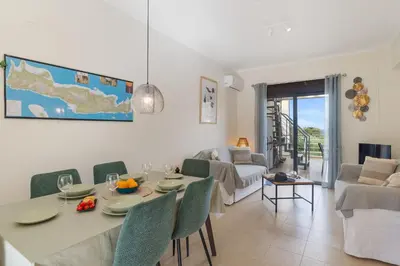a dining room and living room with a table and chairs at Almyrida Bay View House V BY APOKORONAS-VILLAS in Almirida