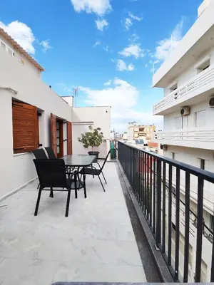a balcony with a table and chairs on a building at Coastal Retreat in Nea Chora in Chania Town
