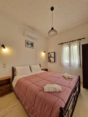 a bedroom with a large bed with two towels on it at Stefanos Garden in Arménoi