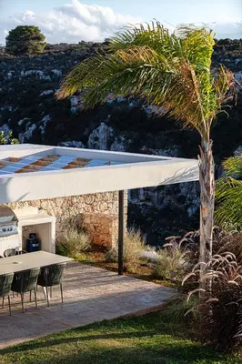 a house with a palm tree and a table and chairs at Blue Olive Luxury Villa in Kounoupidhianá