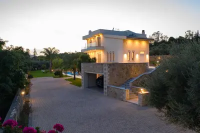 a house with lights on the side of a driveway at Villa Melitini in Souda