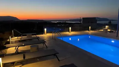a large swimming pool with a sunset in the background at Villa Eleni, Vamos Sea & Mountain View with Pool in Chania