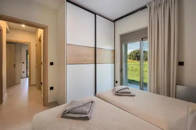 two beds in a bedroom with a large window at Villa JOY in Módhion