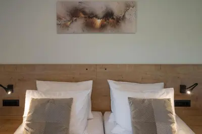 a bed with white pillows and a painting above it at Villa JOY in Módhion