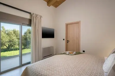 a bedroom with a bed and a large window at Villa JOY in Módhion