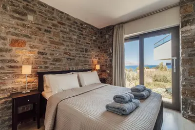 a bedroom with a bed and a brick wall at Villa Kera Panorama by PosarelliVillas in Vamos