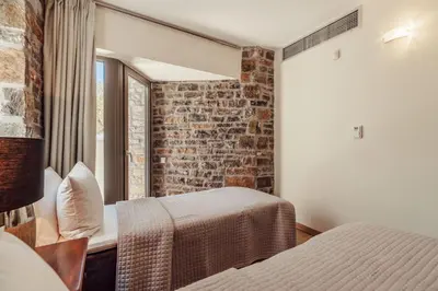 a bedroom with two beds and a brick wall at Villa Kera Panorama by PosarelliVillas in Vamos
