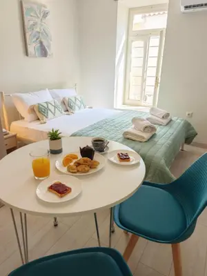 a white table with plates of food on it in a bedroom at Casa di Rosa in Chania Town