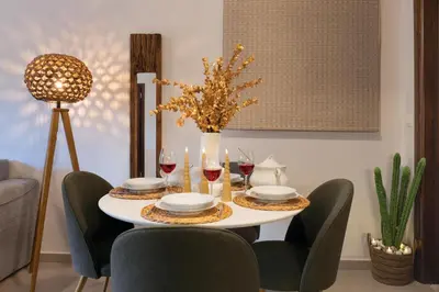 a table with wine glasses and a vase of flowers at Dreamscape Residences - Zephi Suite in Chania Town