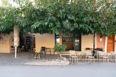 a group of tables and chairs under a tree at Dreamscape Residences - Zephi Suite in Chania Town