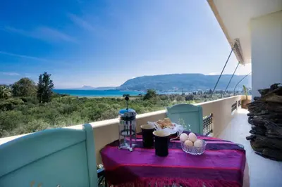 a table on a balcony with a view of the ocean at Penthhouse Studio next to the beach in Souda