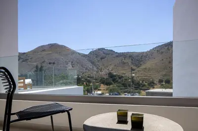 a table and a chair in front of a large window at Imbros Villas I 