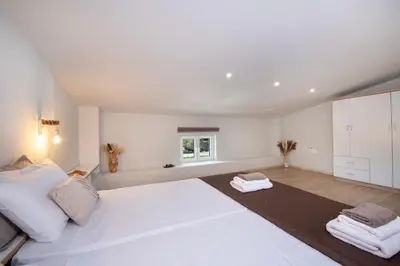 a white bedroom with a large white bed and a window at Casa di Mina's in Chania in Sirílion