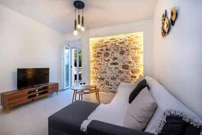 a living room with a couch and a tv at Casa di Mina's in Chania in Sirílion