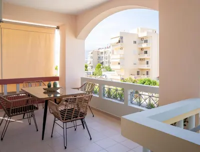 a balcony with a table and chairs and a window at Tessera Alfa city apartment in Chania Town
