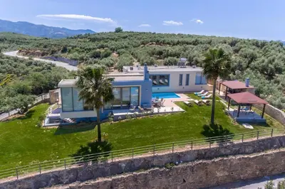 a house on a hill with palm trees at Modern Interior Villa in Chania Town