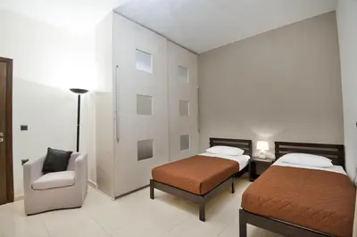 a bedroom with two beds and a chair and a couch at Modern Interior Villa in Chania Town