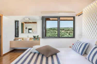 a bedroom with a bed and a sink and a mirror at Villa AnnaNiko, Luxury Villa, 2 Heated Pools, Jacuzzi, Gym, Stunning Views, Green Energy in Gerani Chanion