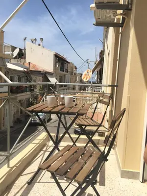 a wooden table on a balcony with cups on it at Kd's apartment B in Chania Town