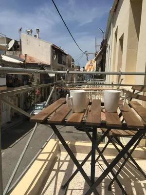 a table on a balcony with two cups on it at Kd's apartment B in Chania Town