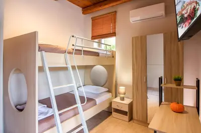 a small room with bunk beds and a flat screen tv at Beautiful Villa in Zounákion