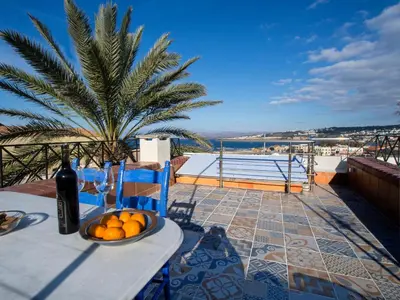 a table with a bowl of oranges on a balcony at Venetian House in Chania Town