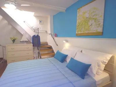 a bedroom with a bed with blue walls and a staircase at Venetian House in Chania Town