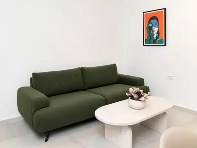 a green couch in a living room with a table at Alma & Nina Apt in Chania Town