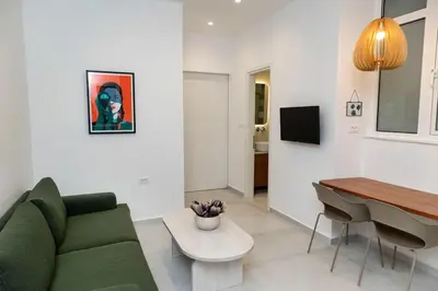 a living room with a green couch and a table at Alma & Nina Apt in Chania Town