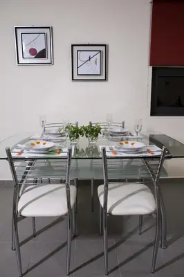 a glass table with chairs and plates on it at Campagna Mare in Kissamos