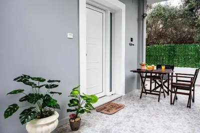 a porch with a table and chairs and a window at Kamari Petit Studio & Apartment - Chania in Chania Town