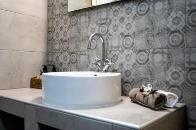 a bathroom sink with a towel on a counter at Kamari Petit Studio & Apartment - Chania in Chania Town
