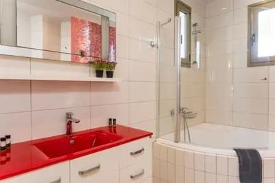 a bathroom with a red sink and a tub at Olive Chrysi Luxury Villa with in-room plunge pool in Chania Town