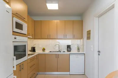 a kitchen with wooden cabinets and a sink at Olive Chrysi Luxury Villa with in-room plunge pool in Chania Town
