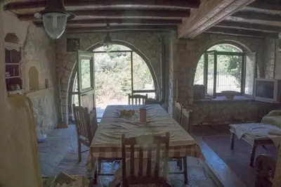 a dining room with a table and chairs in a room at Diving into silence - Traditional Stone House in Kakópetros