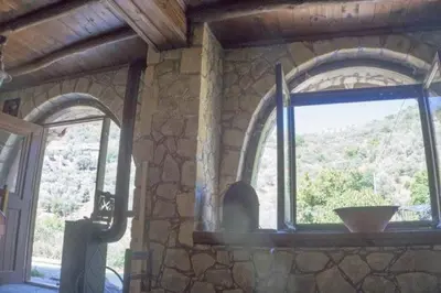 a stone wall with a window in a building at Diving into silence - Traditional Stone House in Kakópetros