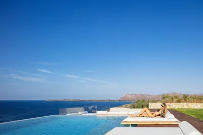 a woman laying on a bed next to a swimming pool at Villa Mika in Chania Town