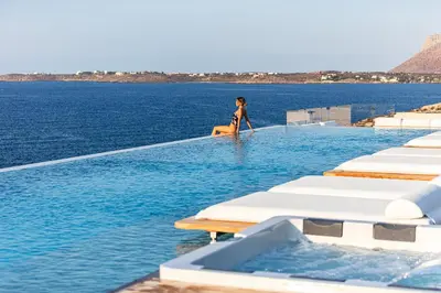 a woman walking on the edge of a swimming pool at Villa Mika in Chania Town