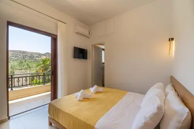 a bedroom with a large bed and a balcony at Villa Aetheria by PosarelliVillas in Plátanos