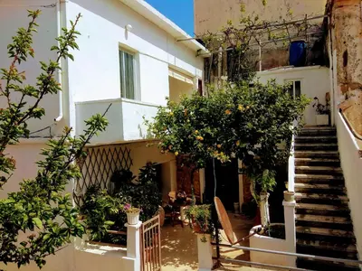 a building with stairs and trees in a courtyard at Three Bedroom Apartment in City Center with Sea View near the Beach in Kissamos