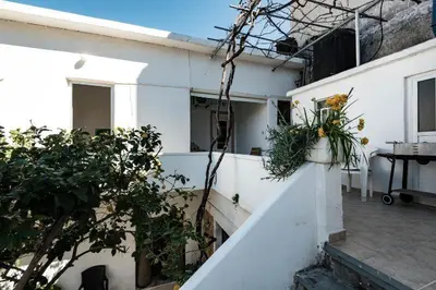 a balcony of a white building with potted plants at Three Bedroom Apartment in City Center with Sea View near the Beach in Kissamos