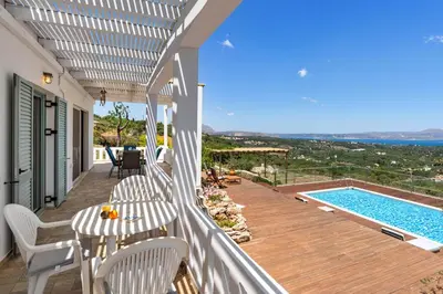 a balcony with a table and chairs and a swimming pool at Villa Helissie in Vamos