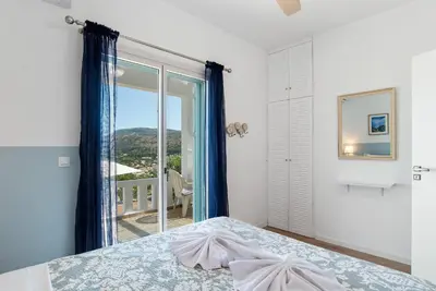 a bedroom with a bed and a large window at Villa Helissie in Vamos