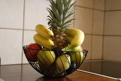 a bowl of fruit with a pineapple and apples at Tholos by Praxithea Stone House & Pool in Gavalochori