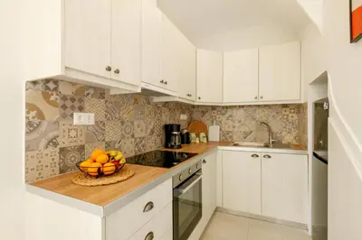 a kitchen with white cabinets and a bowl of fruit at Elartis Apartment in Chania Town