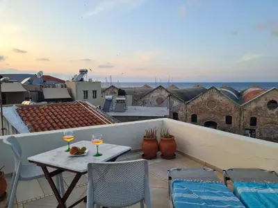 a balcony with a table and two glasses of wine at Casa Argirenia - Venetian Mansion in Old Harbour in Chania Town