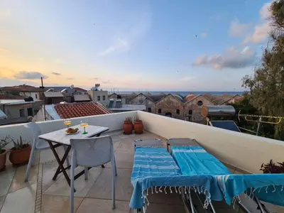 a patio with a table and chairs on a balcony at Casa Argirenia - Venetian Mansion in Old Harbour in Chania Town